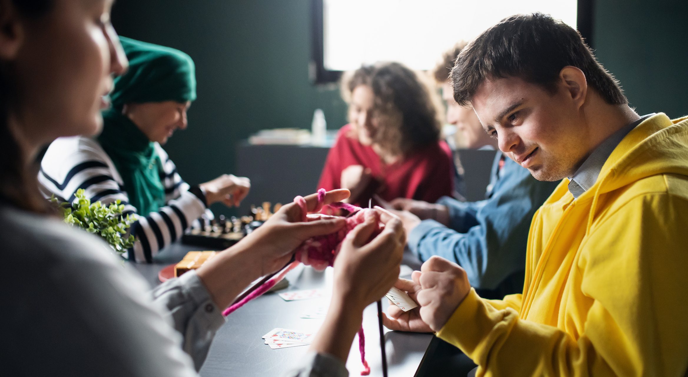Group knitting and playing games at table