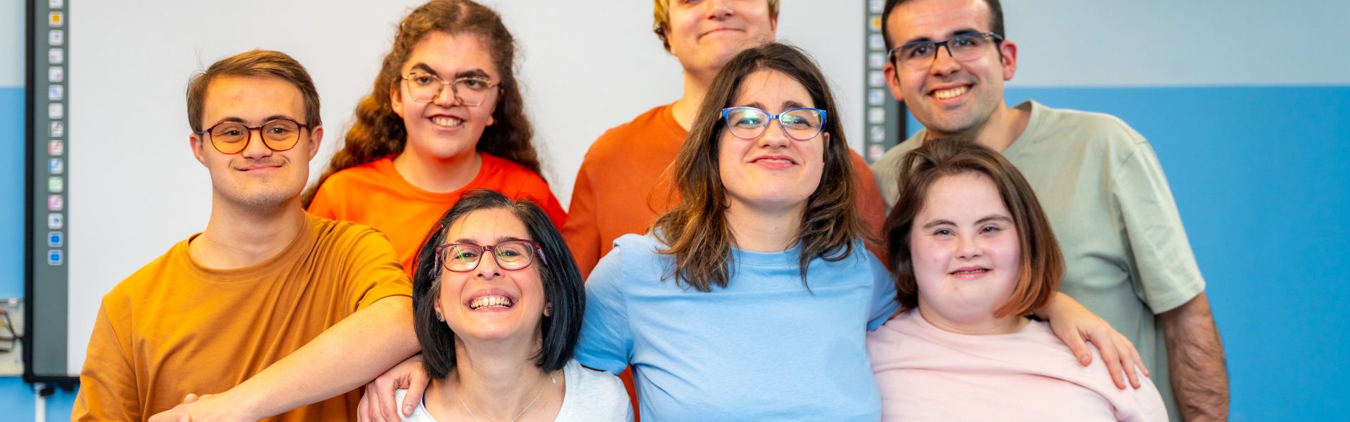 Group of friends smiling together in classroom.