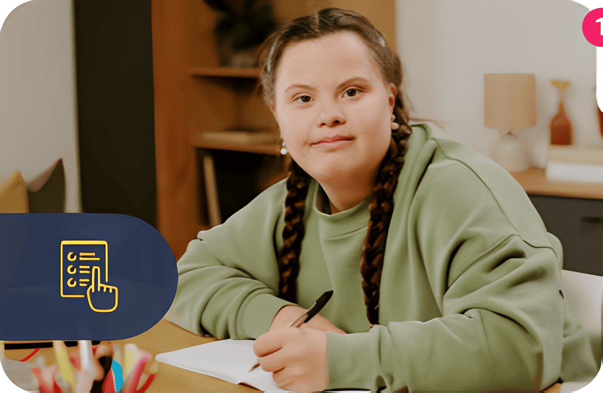 Young girl writing at a desk, smiling.
