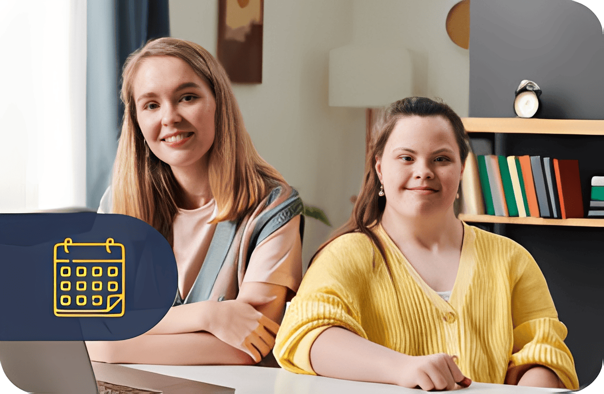 Two women smiling at a desk.